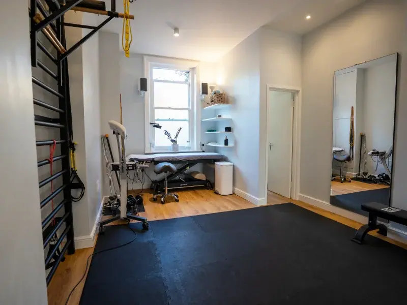 Clinic exercise area with a wall mirror, bench and treatment space